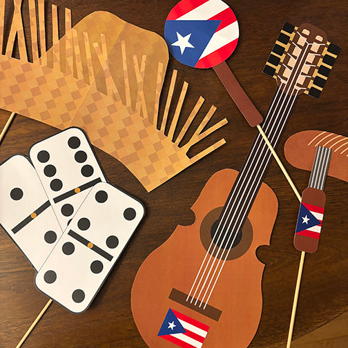 Collection of Puerto Rican-themed photo booth props including a flag, guitar, and traditional instruments on sticks.