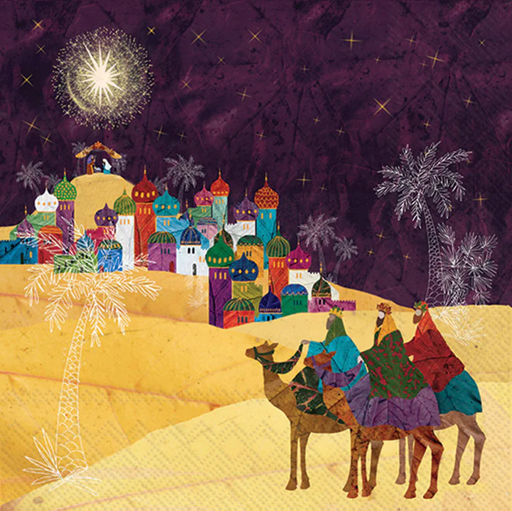 Colorful illustration of the Three Wise Men on camels approaching Bethlehem under a bright star, with vibrant domed buildings and palm trees on festive Christmas-themed paper napkins.