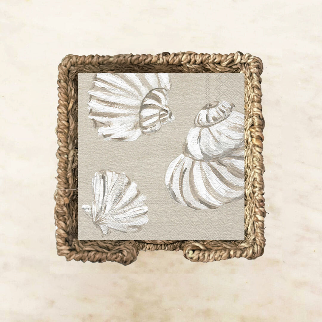 Neutral cocktail napkin featuring hand-painted white seashells on a soft sandy beige background, perfect for coastal parties, beach house entertaining, and seaside events.