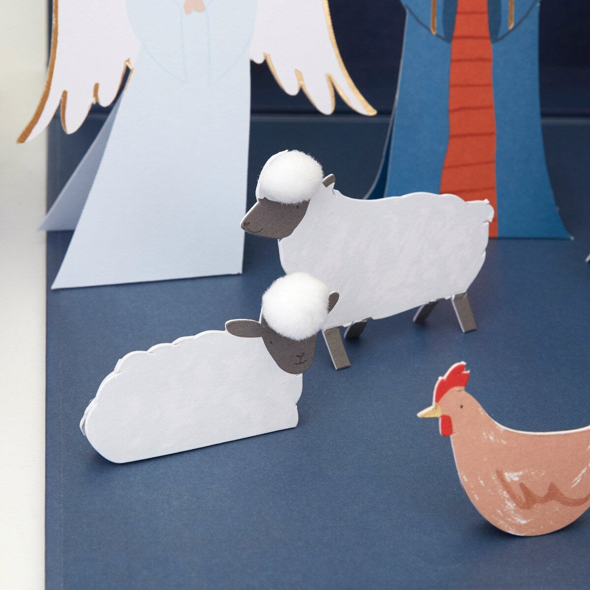 Cardboard cutouts of sheep and a rooster on a blue background