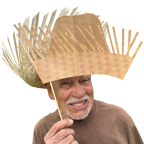 Man wearing a pava hat with a white background. Collection of Puerto Rican-themed photo booth props including a flag, guitar, and traditional instruments on sticks.